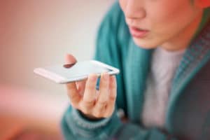 femme qui tient un téléphone dans sa main et qui parle au téléphone
